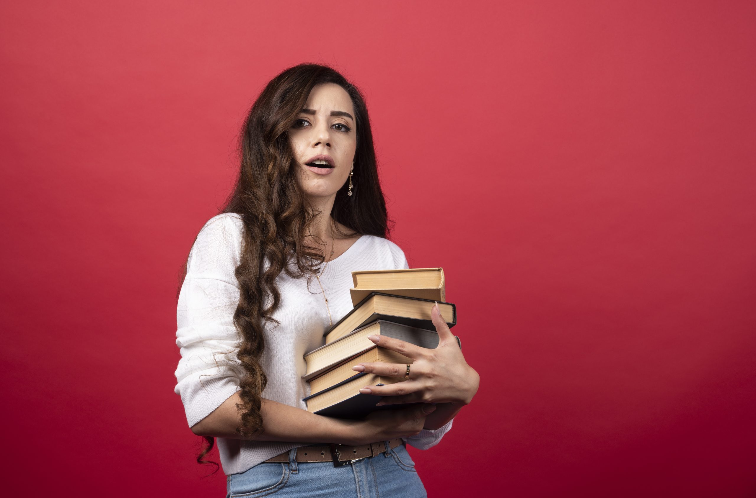 Pretty woman getting tired of carrying books. High quality photo